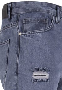 Traperice tamnog pranja s iznošenim detaljem na džepu, s glatkim crnim strukom i klasičnim dizajnom s pet džepova.