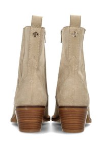 Stivaletti alla caviglia in suede beige con finitura texturizzata, dotati di chiusura con zip, dettagli in metallo dorato e tacchi in legno sovrapposti.