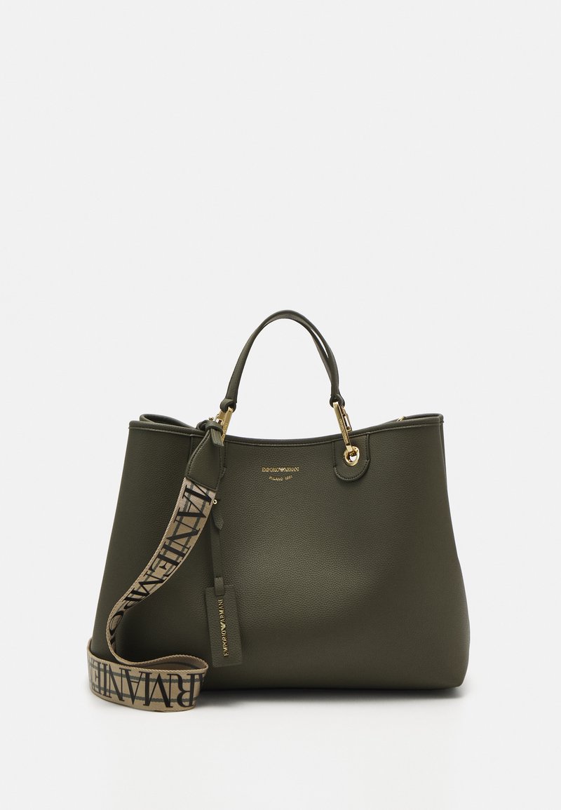 Olive krāsas liela soma, izgatavota no teksturēta materiāla, ar zelta toņu furnitūru, divām rokturiem un rakstainu noņemamu siksnu.