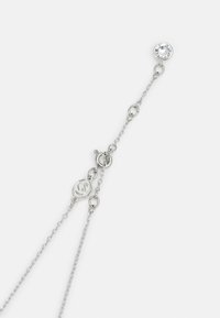 Collar de cadena de plata con un acento de cristal transparente en forma circular. Enlaces delicados y un cierre de langosta para un ajuste seguro.
