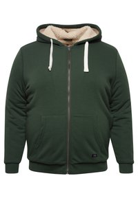 Sudadera verde con cremallera y cordones blancos, interior forrado de felpa, bolsillos frontales, puños y dobladillo acanalados. Presenta una pequeña etiqueta de marca.