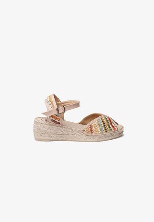 Beige espadrillesandal med vævet stofoverdel, der har flerfarvede zigzag-mønstre, justerbar ankelrem og en juteindpakket kilehæl.