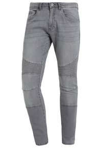 Jeans de denim gris con un corte ajustado, que presentan acentos estriados en las rodillas y un diseño clásico de cinco bolsillos.