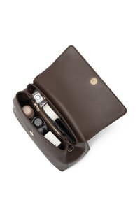 Brown leather handbag with a smooth texture, zippered compartment, and gold hardware. Contains various beauty products inside.
