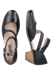 Chaussures en cuir noir avec un bout rond, un design découpé et des sangles réglables. Petit talon bloc texturé et semelle intérieure rembourrée pour le confort.