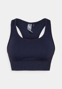 Temno modra športna modrc z gladko teksturo, obliko racerback in sijočim elastičnim trakom na dnu. Oznaka vidna znotraj.