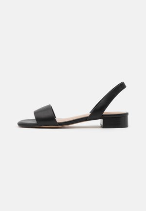 Sort lædersandal med bred fortrop, åben bagdel og en lav blokhæl. Glat tekstur med minimalistisk design.