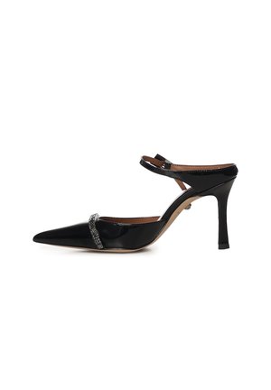 Zapato de tacón alto de charol negro con punta puntiaguda, tira en el tobillo y banda decorativa de pedrería en la parte delantera.