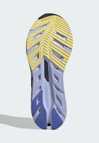 Suola di scarpa sportiva in gomma con un motivo a zigzag. Presenta sezioni gialle, viola e bianche con aperture per la ventilazione e superfici testurizzate.