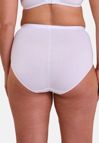 Culotte en coton blanc avec un design sans coutures, taille haute et bordure festonnée à la taille. Texture douce et style minimaliste.