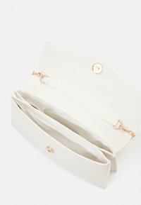 Vit syntetisk läderklutch med ett gyllene tryckknappslås, med två innerfack och en kedjeslynga. Mjuk textur, slät yta.