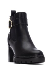 Botín de cuero negro hasta el tobillo con punta redonda, tacón ancho, inserto elástico en el lateral y un acento de hebilla en tono dorado en la correa.