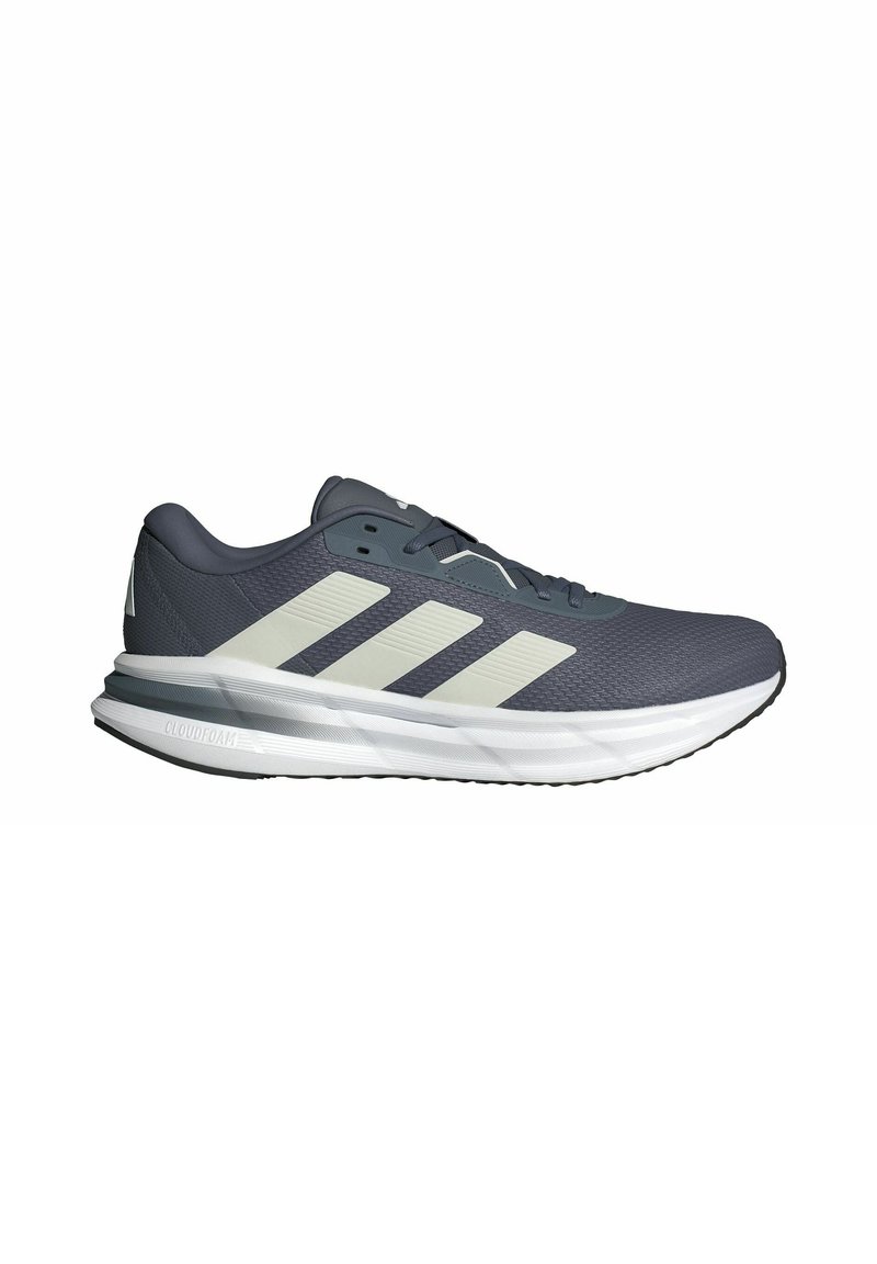 Athletic shoes with a breathable navy mesh upper, three white diagonal stripes, a cushioned white sole, and a textured gray outsole.