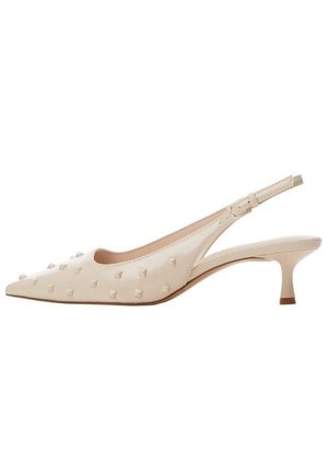 Beige spidse slingbacks med lav kittenhæl, der har en glat læderfinish og fremtrædende pyramideformede nitter over overdelen.