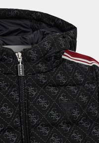 Giubbotto trapuntato nero con un motivo sottile, dotato di cappuccio, chiusura con zip e dettagli a strisce rosse e bianche. Include un logo triangolare del brand.