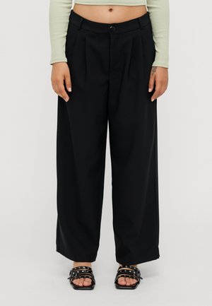 Black wide-leg trousers with pleats, featuring a button closure and a smooth fabric. Worn with black strappy sandals.