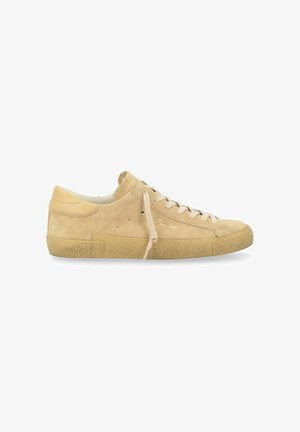 Baskets en suède beige avec une semelle en caoutchouc texturé, bout rond et lacets crème. Présente un branding minimal sur le côté.