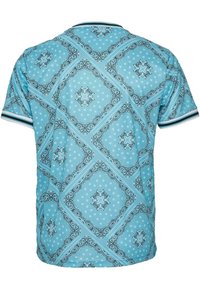 Polo de manga corta azul claro con patrones florales y de paisley intrincados en negro, blanco y azul claro, y puños a rayas en negro y blanco.