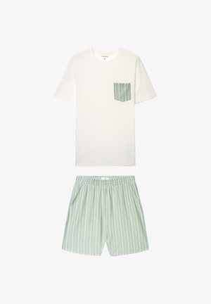 Maglietta leggera in cotone color crema con tasca a righe verdi, abbinata a pantaloncini verde chiaro con vita elastica e strisce verticali bianche.