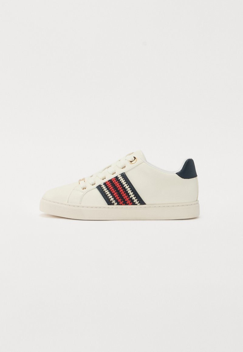 Adidași albi din piele, cu un accent albastru și trei dungi orizontale în roșu, albastru și crem. Ochiuri aurii și o talpă texturată.