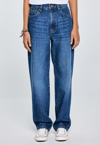 Jeans in denim blu con vestibilità ampia, vita alta, gamba dritta e leggera scoloritura. Presentano tasche anteriori e una chiusura con bottone.