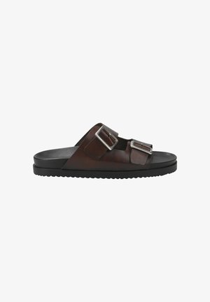Brown leather slide sandals featuring two adjustable silver buckle straps and a black rubber sole with a textured tread pattern.