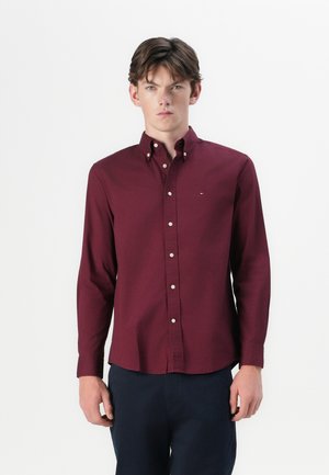 Bordeaux langemouwen overhemd met een button-down kraag, gemaakt van katoen. Beschikt over een klein logo op de borst en een rechte zoom.