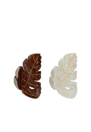Due mollette per capelli a forma di foglia, una marrone scuro e una bianca traslucida, entrambe con dettagli di venature dorate su sfondo bianco.