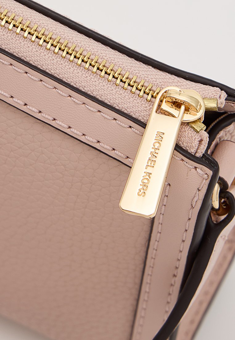 Roze leren handtas met een gestructureerde afwerking, gouden rits en een label met "MICHAEL KORS" gegraveerd. Accentuerend met zwarte randen.