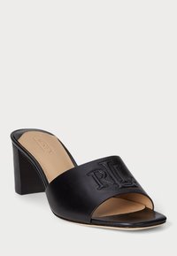 Fekete bőr csúszó szandál nyitott orral, dombornyomott logóval a felső pánton és vastag sarkon. Simás textúra és minimális design.