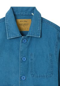 Chemise en denim bleu à boutons pour enfants, avec col pointu, trois boutons et une poche poitrine unique.