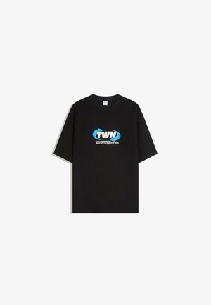 Zwart T-shirt met korte mouwen met blauw-wit "TWN" logo en tekst "Vriendelijke herinnering dat vrede niet het ontbreken van geluid is" op de borst.