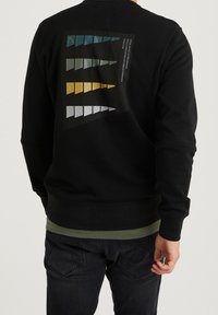 Felpa nera con una grafica sul retro che presenta forme triangolari colorate in blu, verde, giallo e grigio. Polsini e orlo a costine.