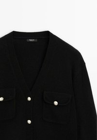 Cardigan nero realizzato in tessuto morbido, con scollo a V, due tasche sul petto con bottoni argentati e un design semplice e strutturato.