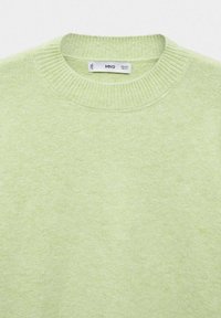 Svetle zelený pletený svetr s kulatým výstřihem. Měkká textura a vroubkované manžety. Viditelný štítek MNG uvnitř límce.