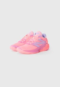 Sportssko med en pink mesh overdel, lilla detaljer og en struktureret gummisål. Har et snørelukningsdesign med branding på tungen.