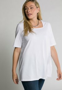 Camiseta blanca de manga corta, con escote cuadrado y corte relajado. Fabricada en una tela suave, con aberturas laterales para mayor comodidad.