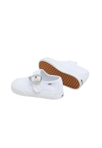 Białe płócienne trampki z okrągłym czubkiem, regulowanym paskiem na klamrę i gumową podeszwą z wzorem w wafle dla lepszej przyczepności.