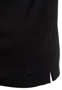 Schwarzes, geripptes Stoffshirt mit seitlichem Schlitz und kleinem Metall-Logo-Detail am Saum. Dünnes, strukturiertes Material mit figurbetontem Schnitt.