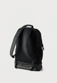 Μαύρο σακίδιο πλάτης με υφή υφάσματος, επενδυμένους ιμάντες ώμων, πίσω πάνελ από δίχτυ και ανθεκτικό κάτω μέρος. Διαθέτει λεπτομέρειες με κορδόνι.