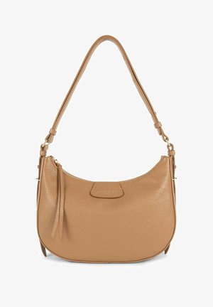 Sac à épaule en cuir tan avec une forme incurvée, un patch logo et une longue bandoulière. Présente une texture douce et un petit détail de frange.