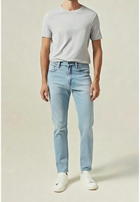 Jean en denim bleu clair à coupe droite, associé à un t-shirt gris ajusté. Des baskets blanches complètent la tenue. Design simple, sans motifs.