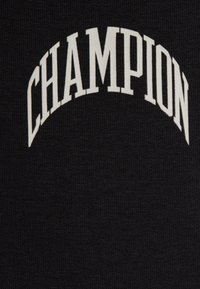 Černá látka s strukturovaným povrchem, na které je uprostřed zakřivený bílý text "CHAMPION". Jednoduchý, čistý design bez dalších vzorů.