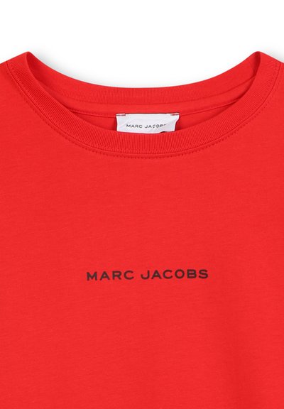 Czerwona bawełniana koszulka z okrągłym dekoltem i krótkimi rękawami. Z przodu znajduje się nadrukowane czarne logo "MARC JACOBS". Gładka faktura.