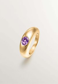 Anillo de oro con una piedra de amatista ovalada engastada en una banda lisa y pulida. El diseño presenta una forma redondeada y un acabado elegante y brillante.