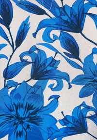 Blaues Blumenmuster zeigt große Lilien in verschiedenen Blautönen und mit schwarzen Umrissen auf einem weißen Hintergrund, umgeben von wirbelnden Blättern und Blütenblättern.