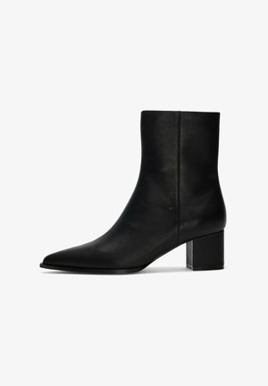 Juodi odiniai kulkšnies aulinukai su smailia koja ir storo blokiniu kulnu. Lygi tekstūra, minimalistinis dizainas ir vientisas apdaila.