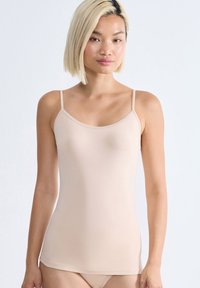 Beige tílko s tenkými ramínky, vyrobené z hladkého materiálu. Má zaoblený výstřih a přiléhavý střih, ideální k vrstvení.