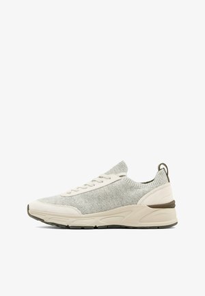 Sneaker grigia chiaro in maglia con dettagli in camoscio beige, chiusura frontale con lacci, suola ammortizzata e linguetta sul tallone, vista di profilo.