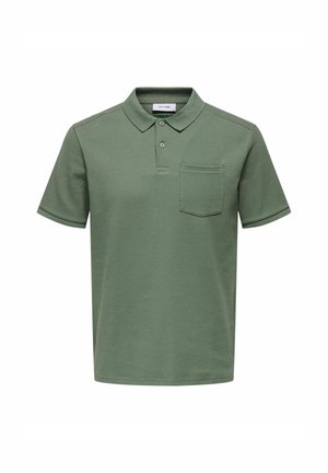 Vihreä polo-paita, joka on valmistettu teksturoidusta kankaasta. Paita sisältää kauluksen, kaksipainikkeisen avauksen ja rintataskun. Lyhyet hihat ja yksivärinen muotoilu.